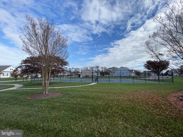 a green field with lots of trees in the background