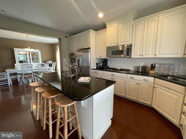 a kitchen with stainless steel appliances granite countertop a stove a sink a microwave and a refrigerator