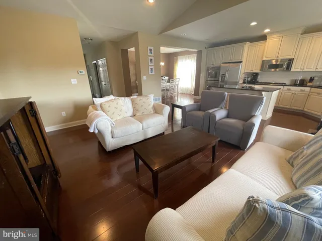 a living room with furniture wooden floor and a large window