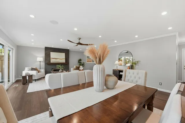 a living room with furniture a flat screen tv and a dining table