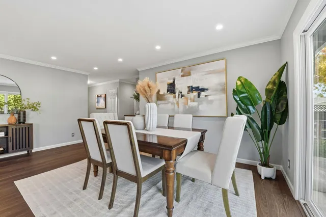a dining room with furniture and a potted plant