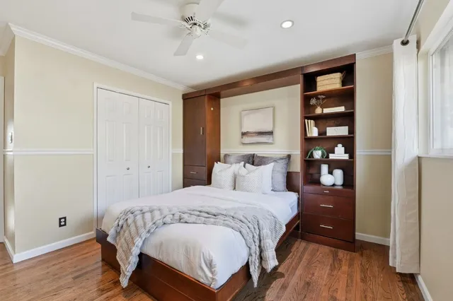 a bedroom with a bed and wooden floor