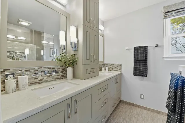 a bathroom with a double vanity sink a mirror and a shower