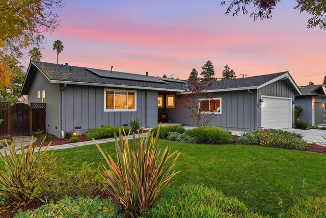 a backyard of a house with plants and wooden fence