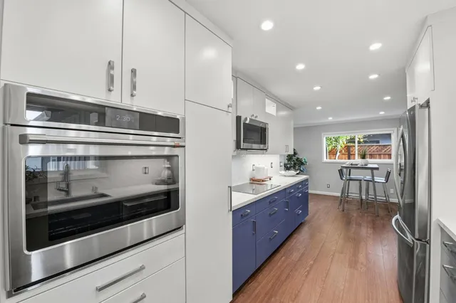 a kitchen with stainless steel appliances kitchen island granite countertop a stove and a microwave
