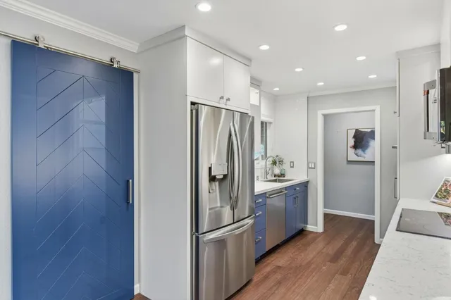 a kitchen with stainless steel appliances granite countertop a refrigerator and a sink