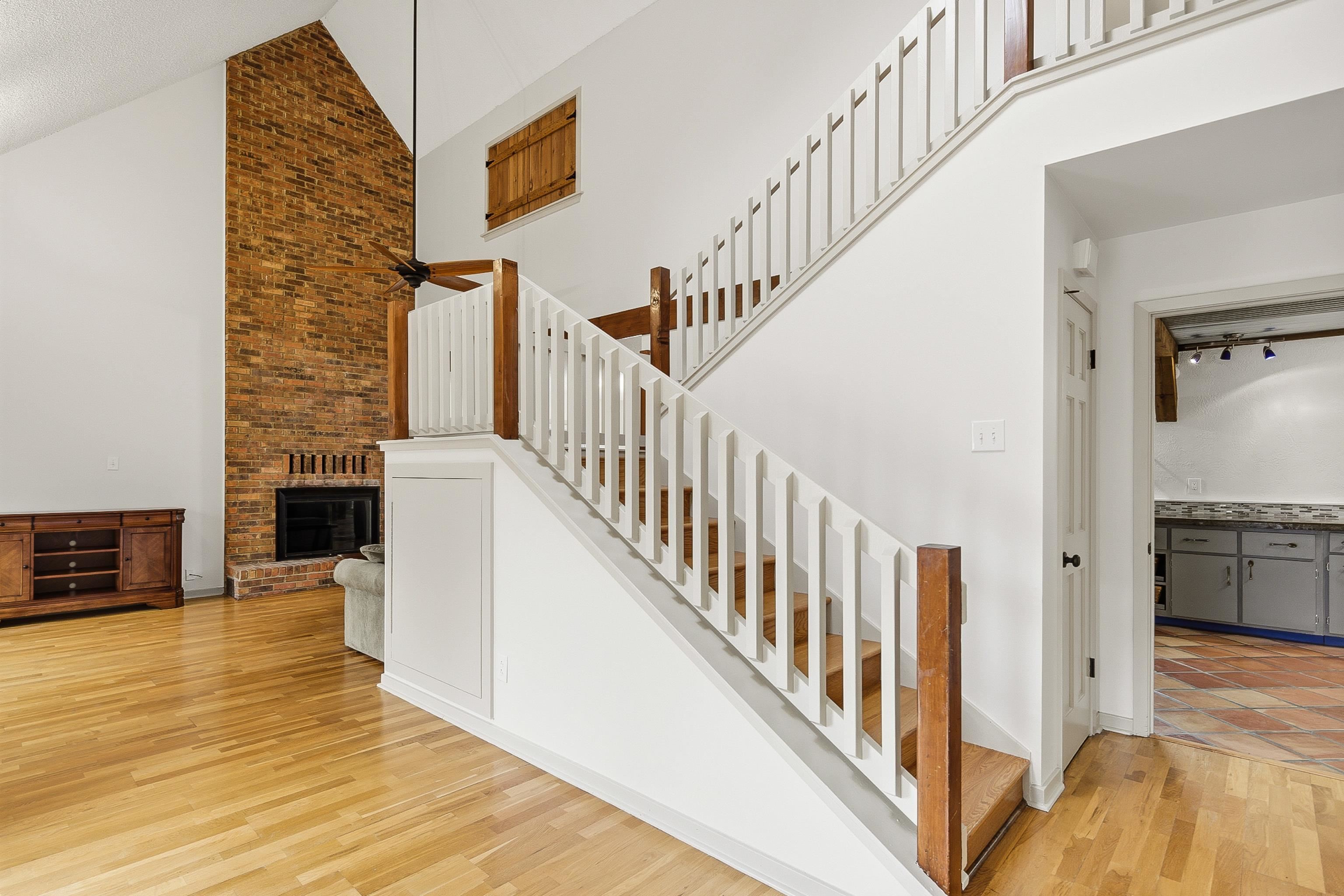 1833 New Riverdale Road Germantown, TN 38138 - Photo 6 of 40 a view of staircase with wooden floor and a fireplace