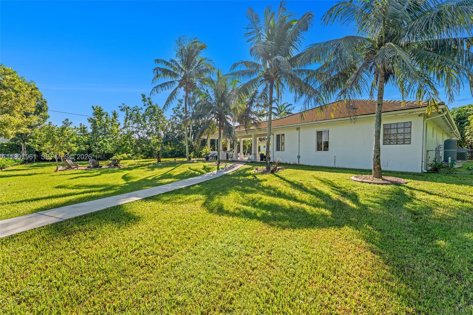 21331 Southwest 246th Street Homestead, FL 33031 - Photo 22 of 34 a view of a swimming pool with a yard and palm trees