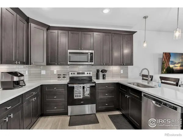 a kitchen with kitchen island granite countertop a sink stainless steel appliances and cabinets