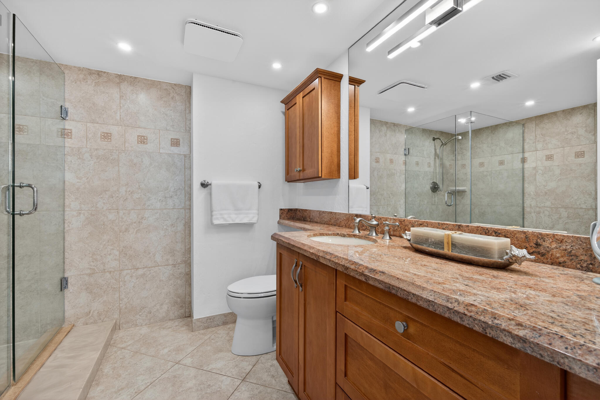 4200 North Ocean Avenue, Unit 11101 Riviera Beach, FL 33404 - Photo 21 of 35 a bathroom with a granite countertop sink a toilet and shower