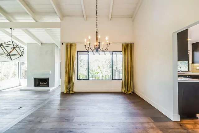 a view of an empty room with window and wooden floor