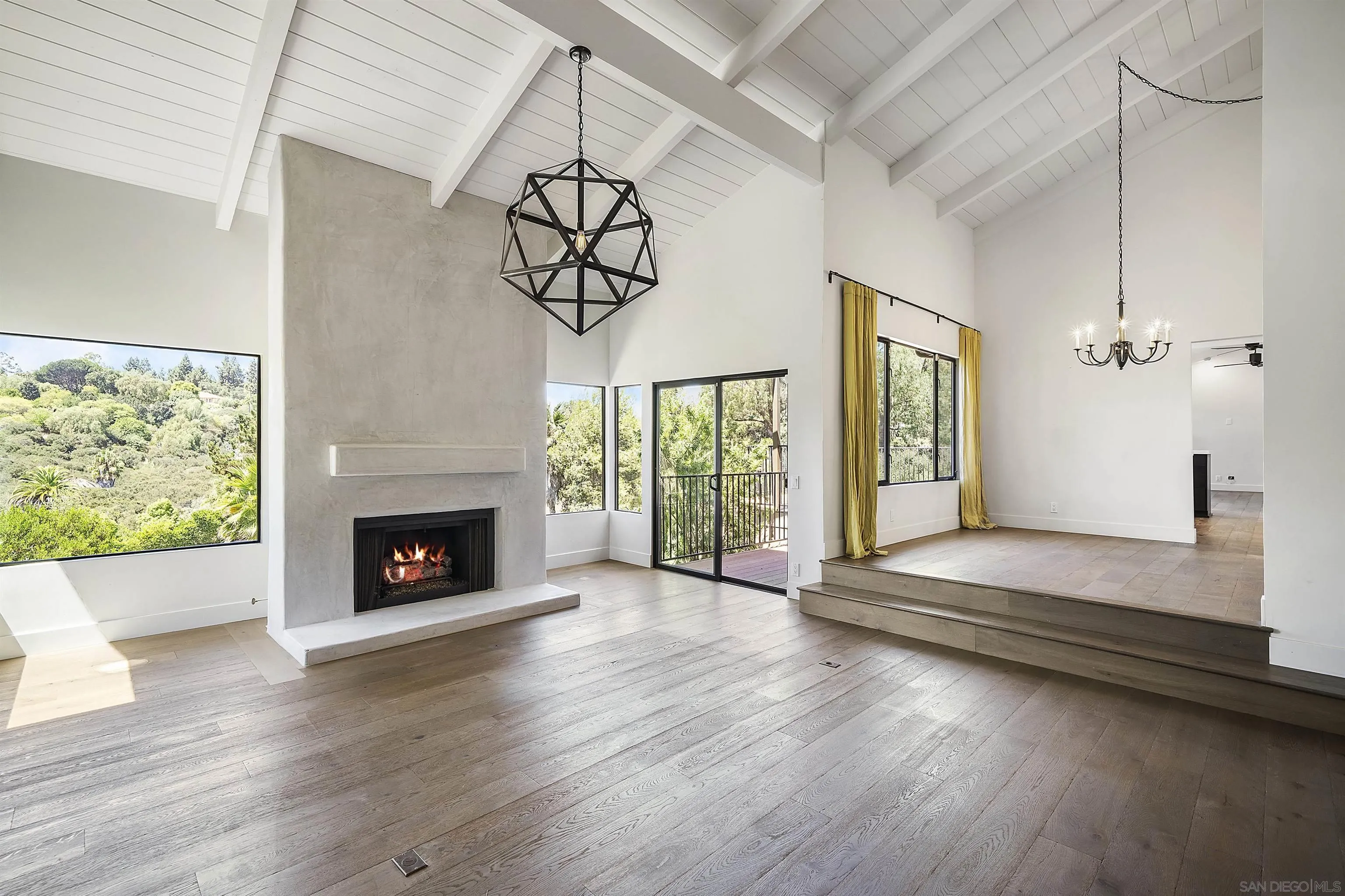 17335 Via Del Bravo Rancho Santa Fe, CA 92067 - Photo 8 of 47 an empty room with wooden floor a fireplace and windows
