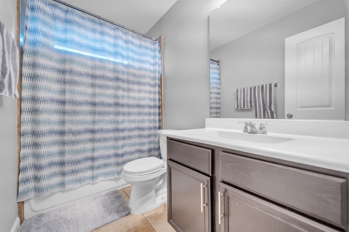 1230 Maple Ace Drive Katy, TX 77493 - Photo 30 of 40 a bathroom with a sink a toilet a mirror and shower curtain