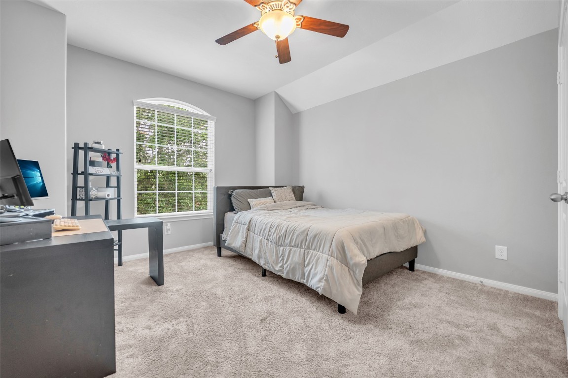 1230 Maple Ace Drive Katy, TX 77493 - Photo 35 of 40 a spacious bedroom with a large bed and a chandelier