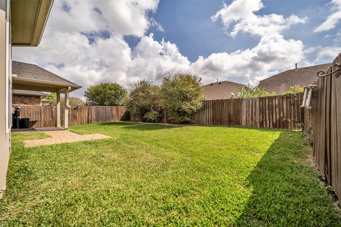 1230 Maple Ace Drive Katy, TX 77493 - Photo 39 of 40 A spacious, fenced backyard with lush green grass, ideal for outdoor activities.
