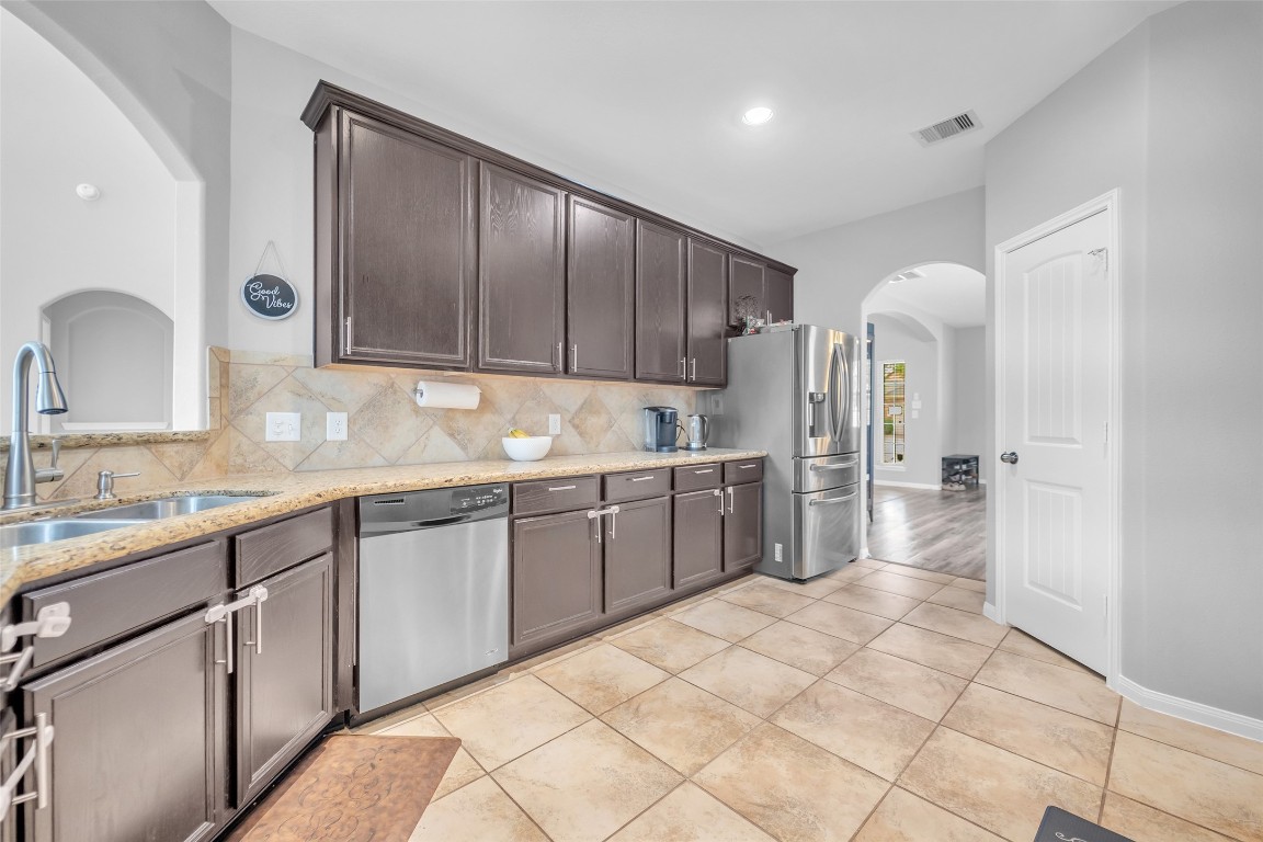 1230 Maple Ace Drive Katy, TX 77493 - Photo 9 of 40 a large kitchen with kitchen island granite countertop a sink cabinets and stainless steel appliances