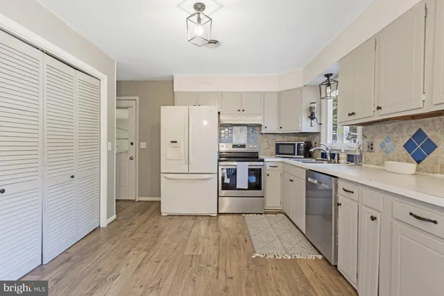 a kitchen with cabinets a refrigerator and a stove top oven