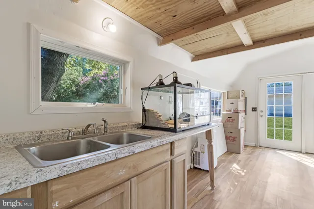 a kitchen that has a sink a stove and a wooden floor