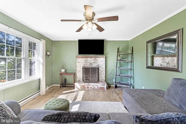 a living room with furniture a fireplace and a flat screen tv
