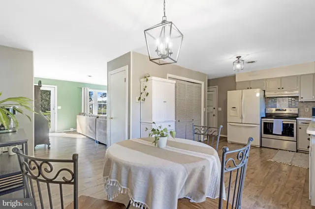 a large kitchen with stainless steel appliances a dining table chairs and chandelier