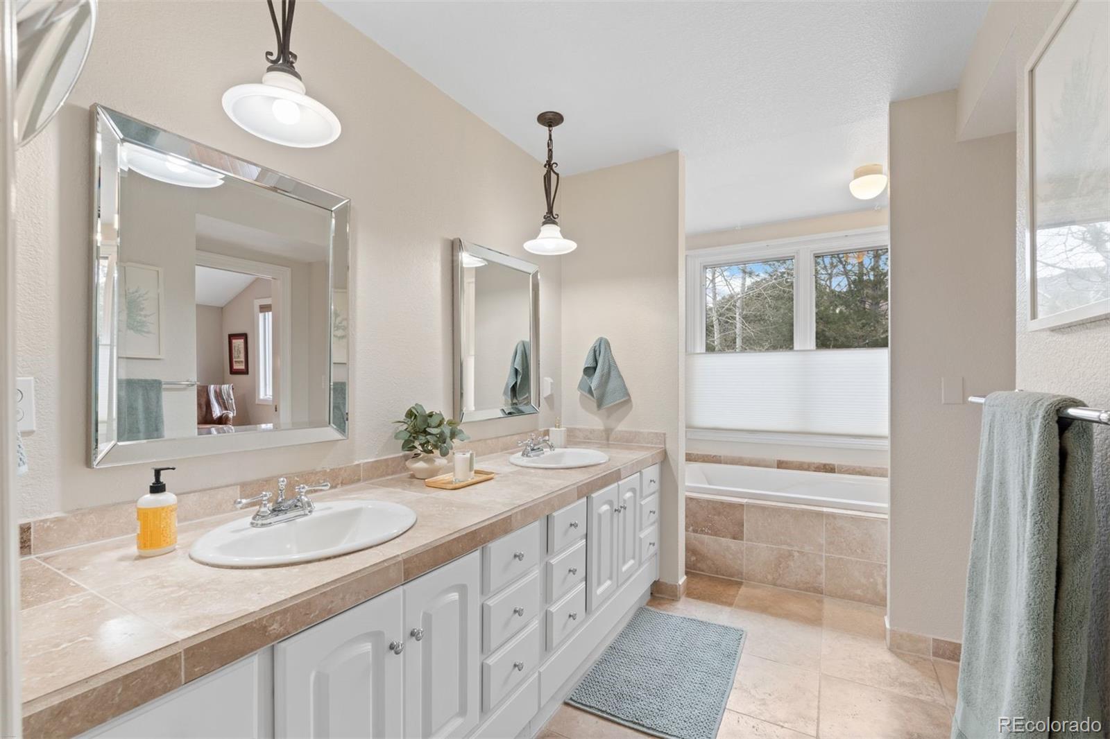 32430 Inverness Drive Evergreen, CO 80439 - Photo 20 of 50 a bathroom with a sink a vanity and a mirror
