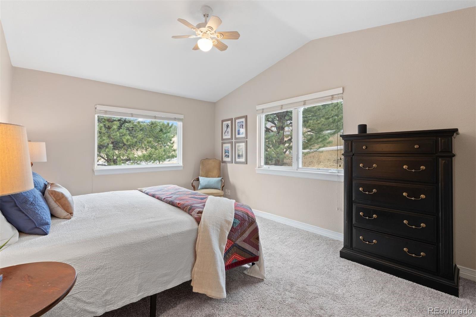 32430 Inverness Drive Evergreen, CO 80439 - Photo 24 of 50 a bedroom with a bed a lamp and a window