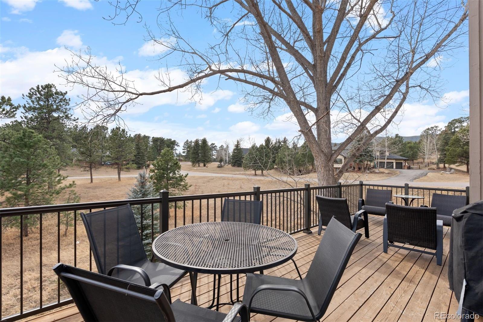 32430 Inverness Drive Evergreen, CO 80439 - Photo 30 of 50 a view of a deck with mountain view and wooden floor