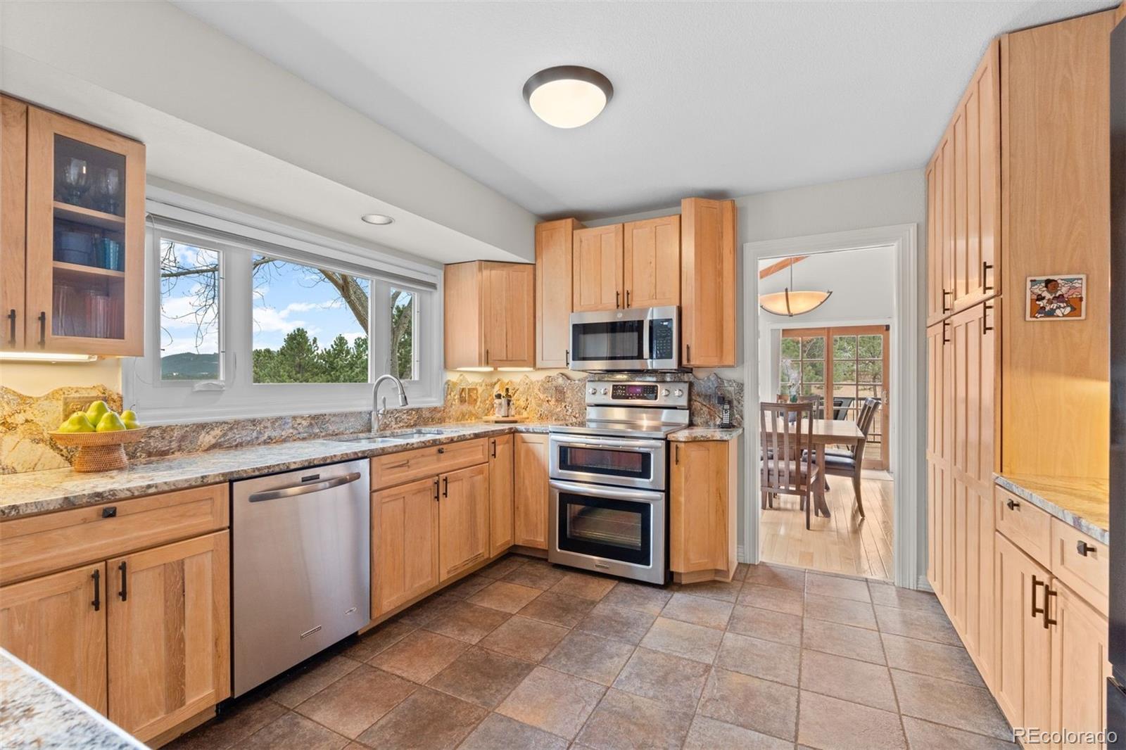 32430 Inverness Drive Evergreen, CO 80439 - Photo 6 of 50 a kitchen with stainless steel appliances granite countertop a stove top oven a sink and a refrigerator