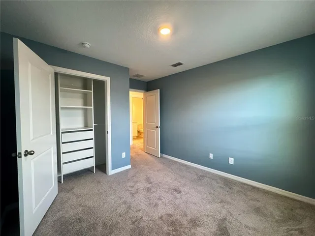 an empty room with closet and a bathroom