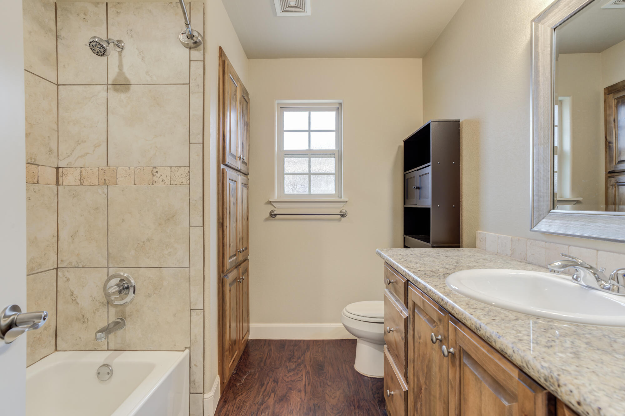 5220 Marshall Street Lubbock, TX 79416 - Photo 11 of 14 a bathroom with a granite countertop sink toilet and shower