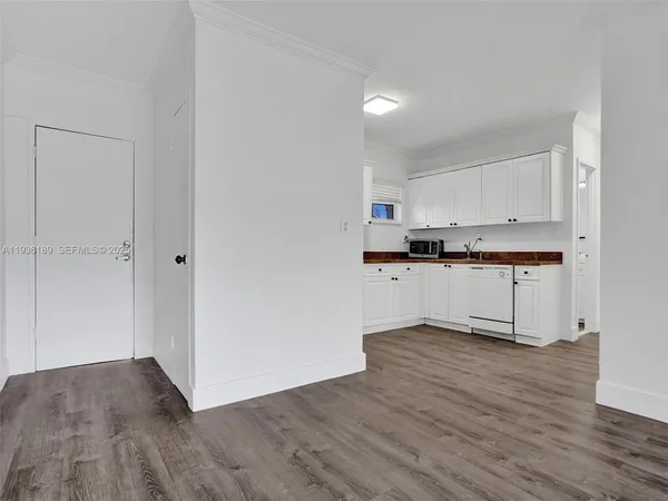 a view of kitchen with granite countertop cabinets and wooden floor