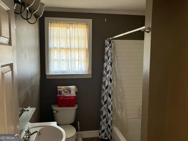 a bathroom with a toilet and a shower curtain