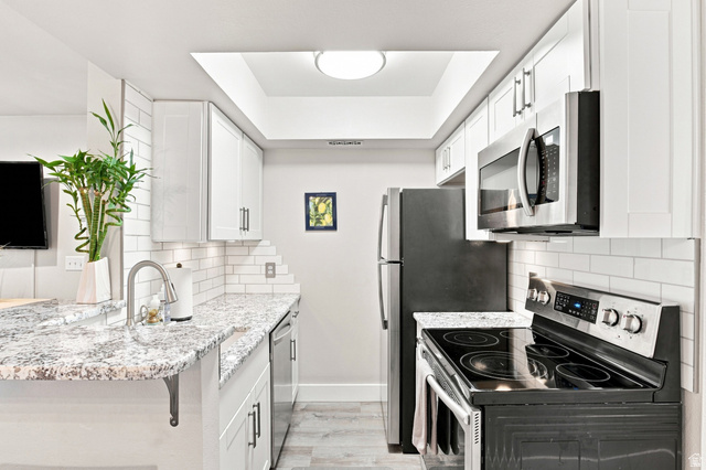 985 Springcrest Court, Unit 11 Midvale, UT 84047 - Photo 9 of 27 Kitchen featuring white shaker-style cabinetry, granite-finish countertops, stainless steel appliances, and subway tile backsplash