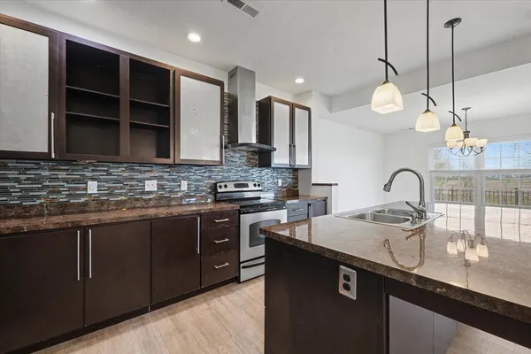 a kitchen with kitchen island granite countertop a sink stainless steel appliances and cabinets