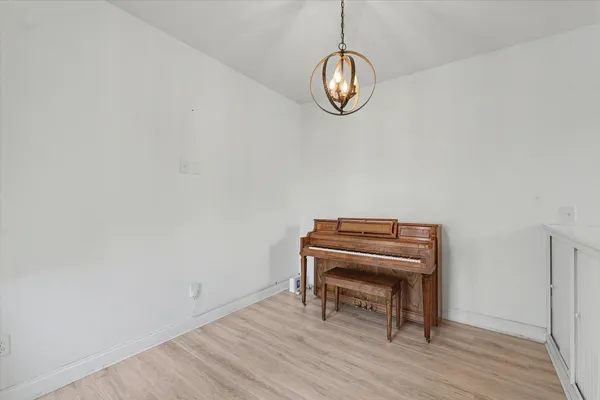 a view of a room with wooden floor and a piano