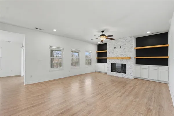 a view of an empty room with a kitchen and a window