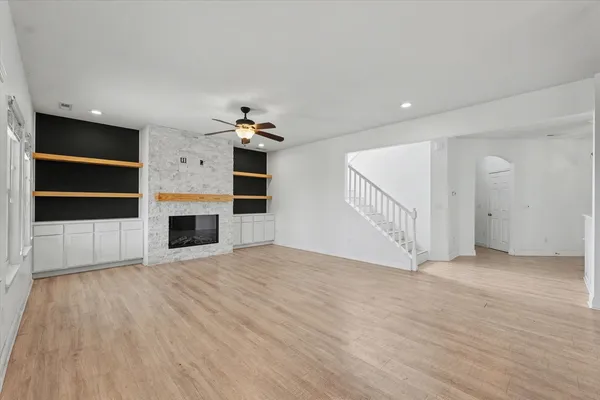 a view of empty room with wooden floor and fireplace