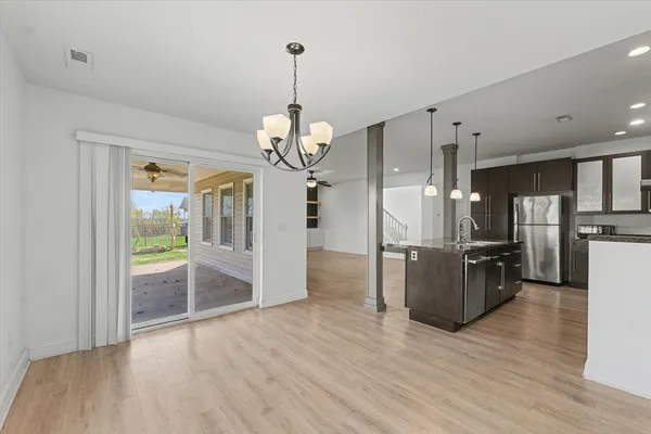 a view of a kitchen with wooden floor and stainless steel appliances