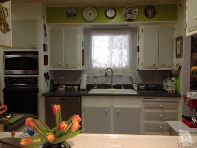 1225 South Rice Road, Unit 49 Ojai, CA 93023 - Photo 12 of 20 a kitchen with stainless steel appliances granite countertop a stove and a microwave