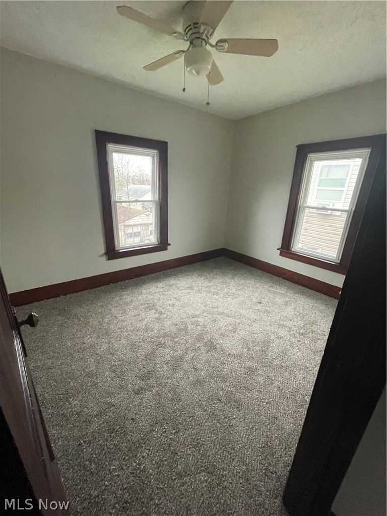 933 Inman Street Akron, OH 44306 - Photo 14 of 25 Carpeted empty room with plenty of natural light and ceiling fan