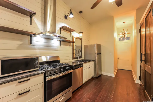 a kitchen with stainless steel appliances and wooden floor