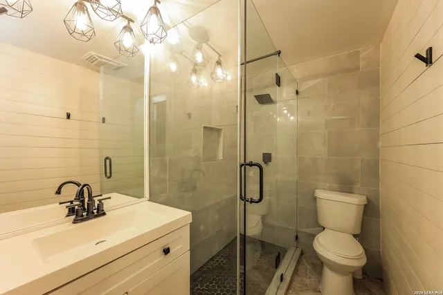 a bathroom with a sink mirror toilet and shower