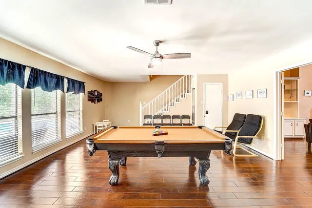a room with wooden floor and pool table