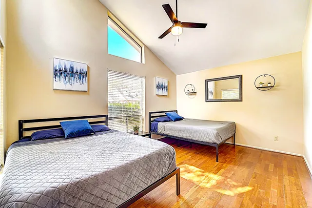 a bedroom with 2 bed and a chandelier