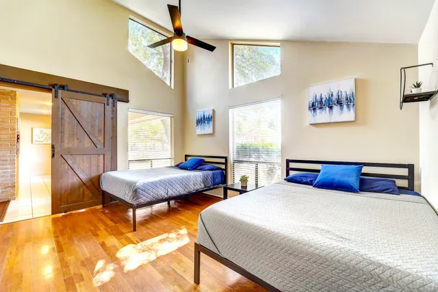 a bedroom with 2 bed and a window