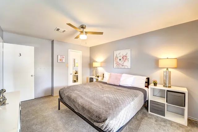 a bedroom with a large bed and a chandelier