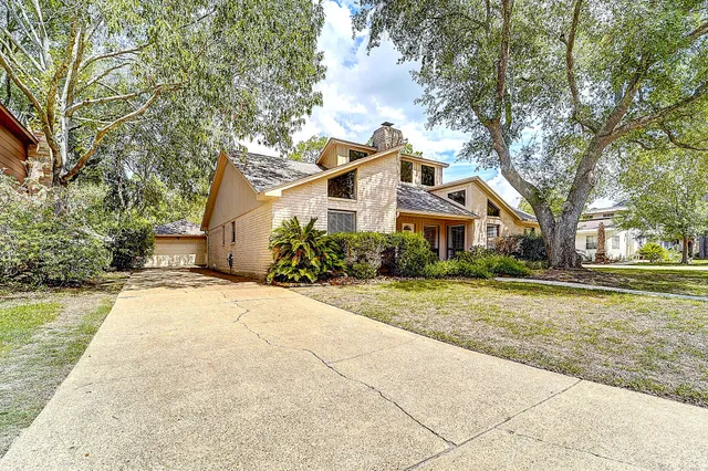 a front view of a house with a yard and trees