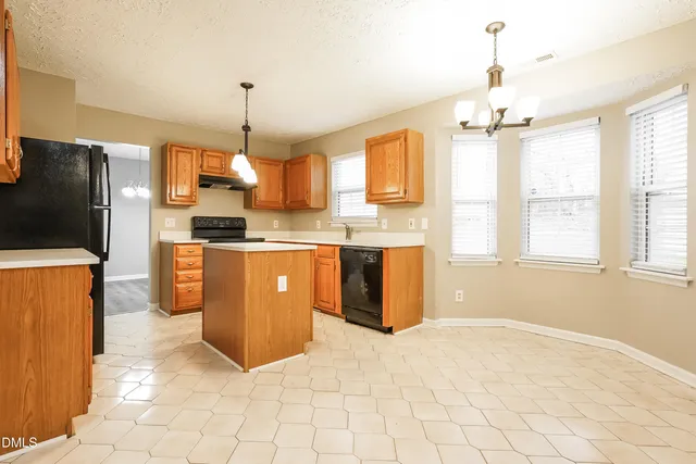 a kitchen with stainless steel appliances granite countertop a stove a sink a refrigerator and cabinets