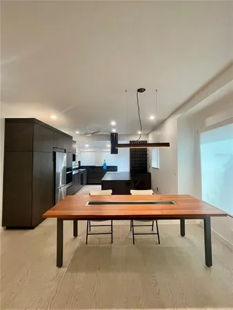 a room with stainless steel appliances kitchen island a table and chairs in it
