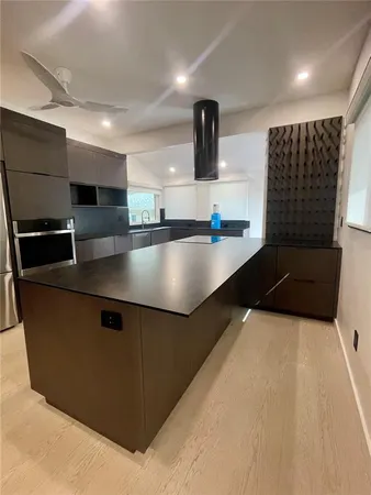 a kitchen with stainless steel appliances granite countertop a sink and a refrigerator